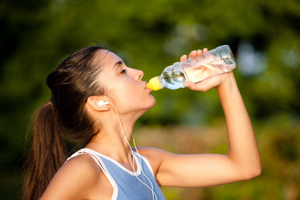 Young Woman Drinking Water After Fitness Exercise