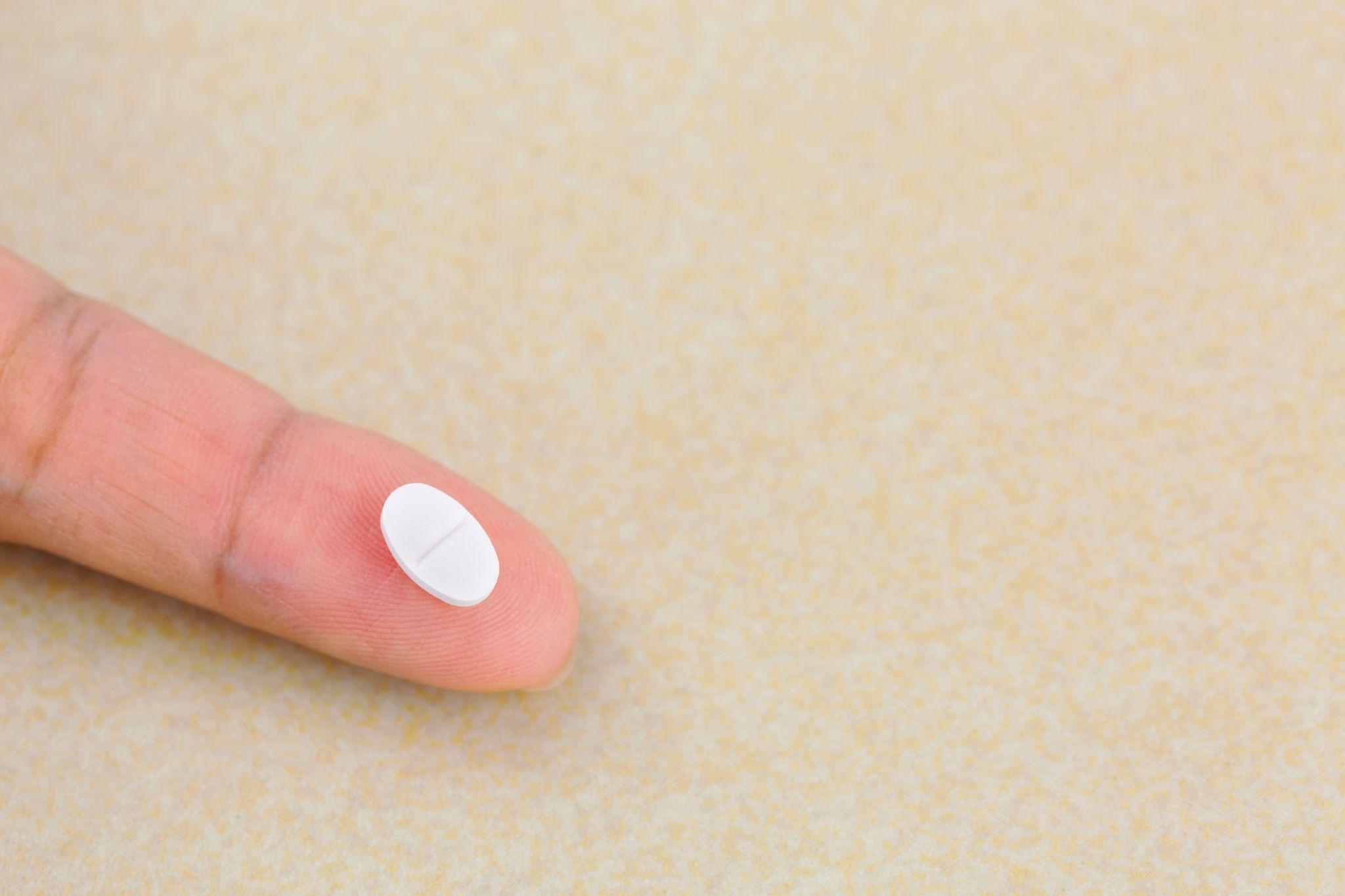 Anti anxiety white pill medicine on finger