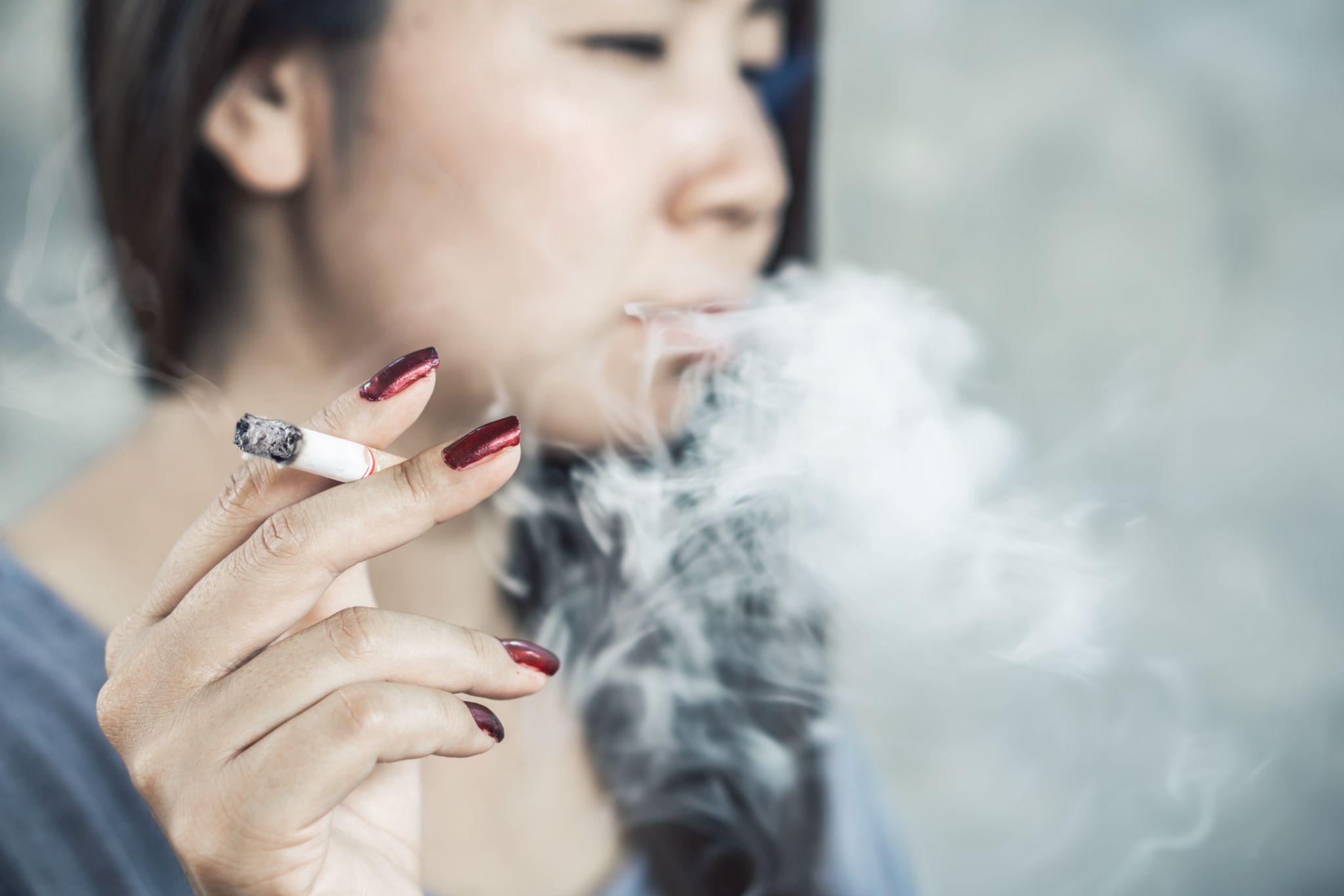 Asian woman hand smoking cigarette