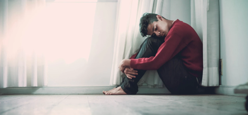 Depressed Young Man Sitting On The Floor