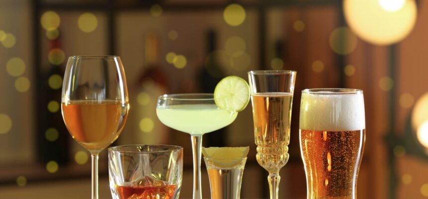 different alcohol drinks on wooden table indoors