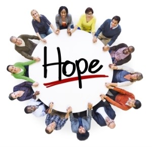 circle of people holding hope sign