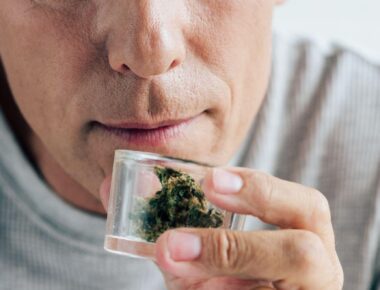 Man smelling medical cannabis in apartment