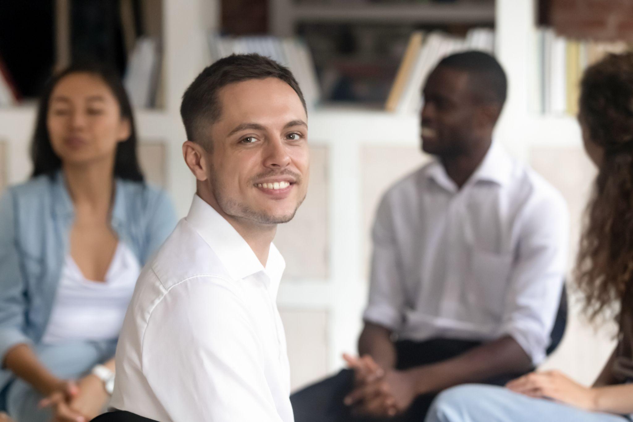 Relieved Caucasian man posing at group therapy session