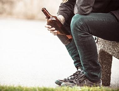 man sitting on bench with beer