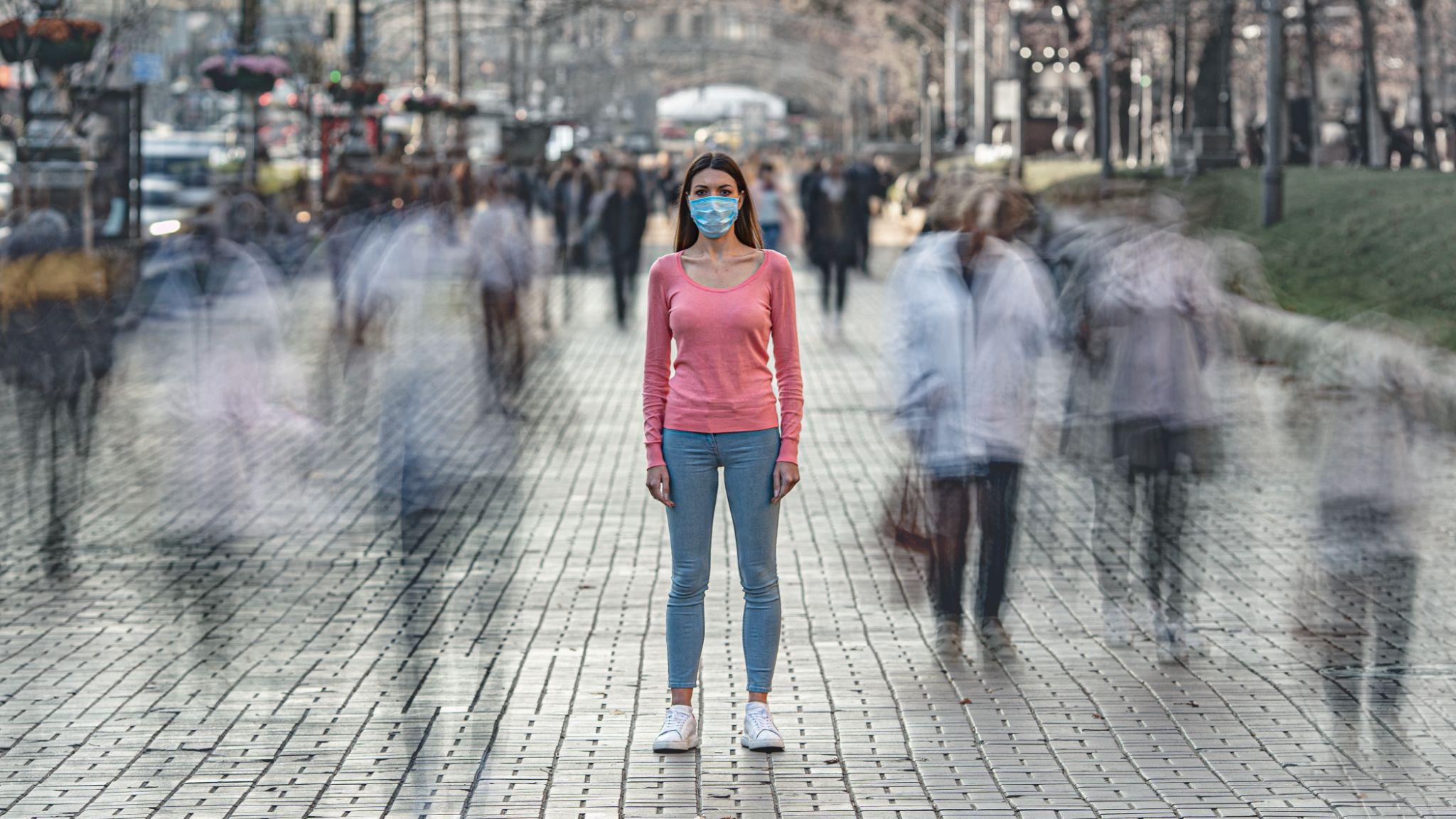 The Woman With Medical Face Mask Stands On The Crowded Street