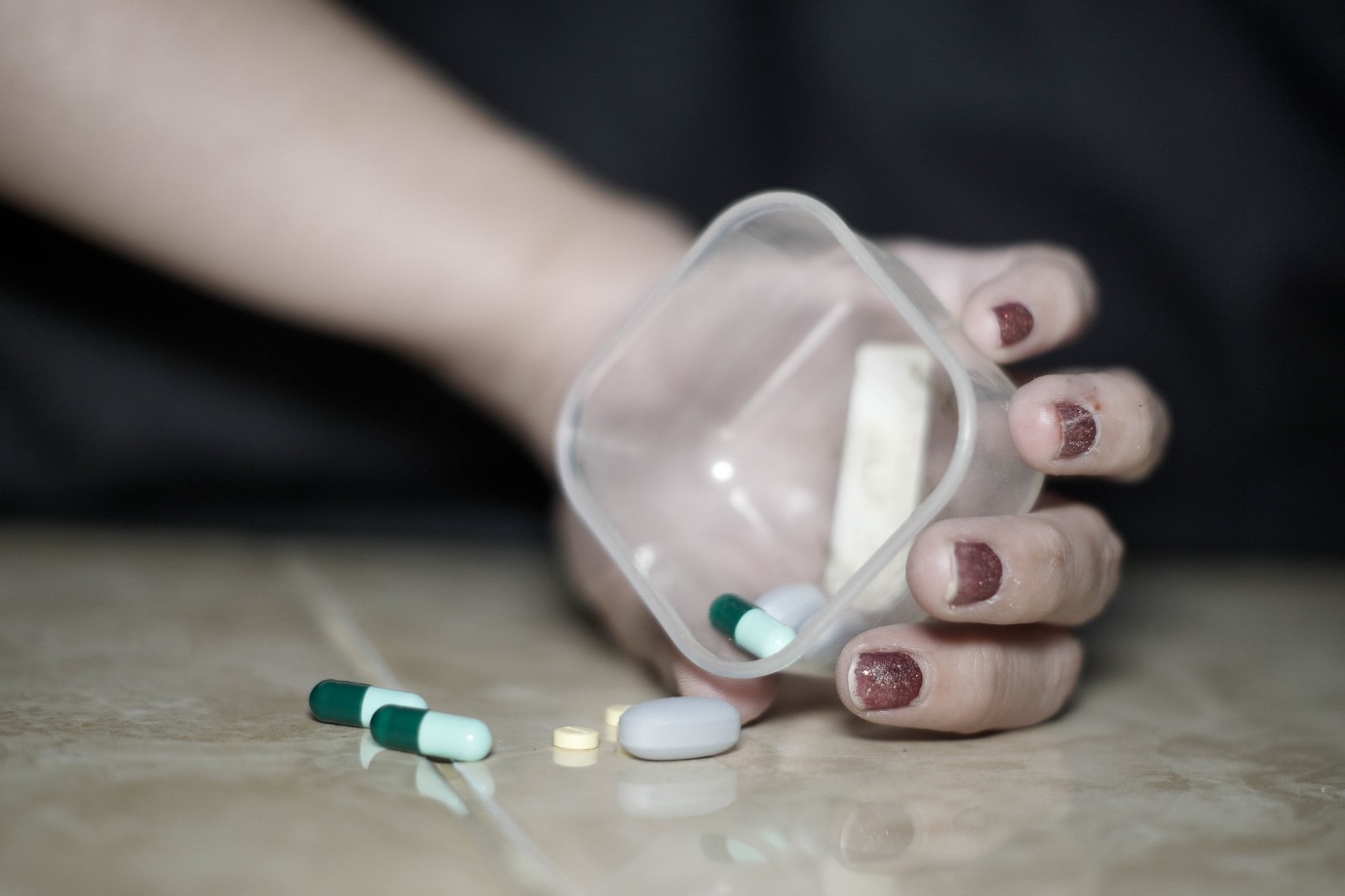 woman holding container and different pills