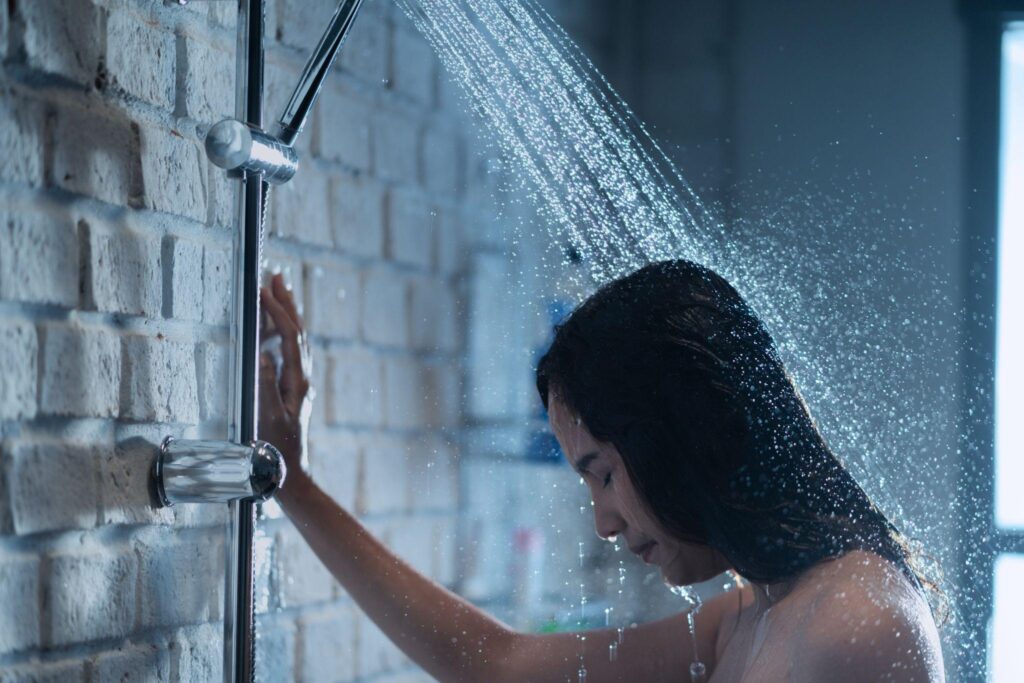 woman with head down in shower