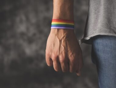 young man with a rainbow-patterned ribbon tied to his wrist