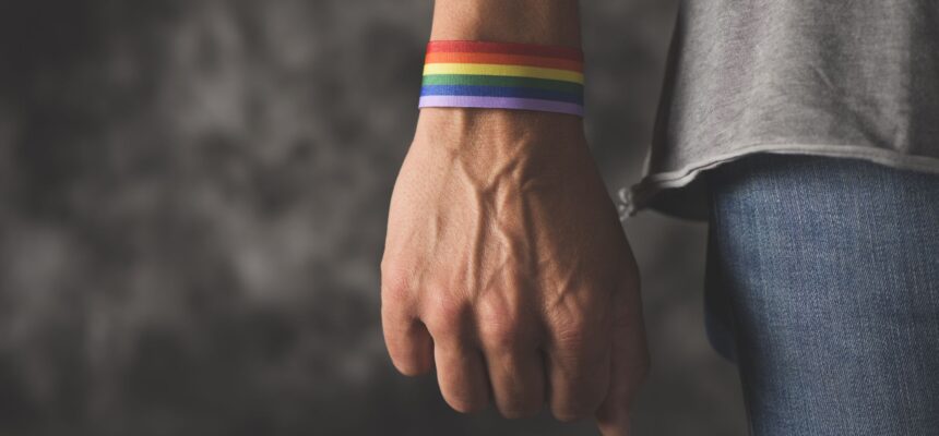 young man with a rainbow-patterned ribbon tied to his wrist